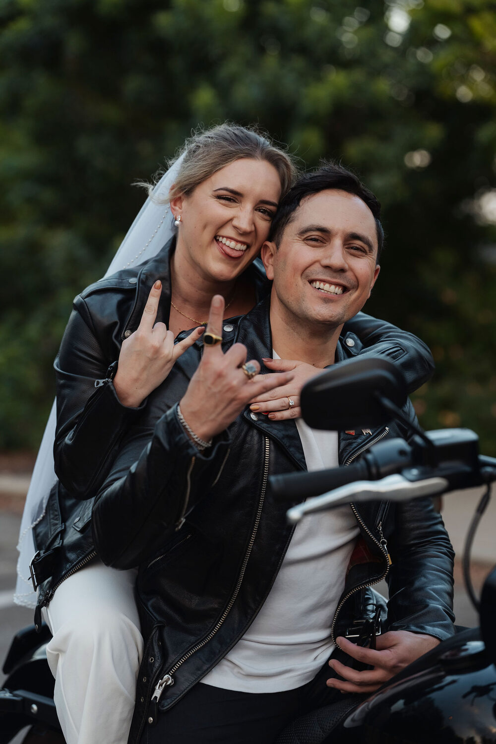 Akylah and Chad on a motorcycle with the city skyline behind them